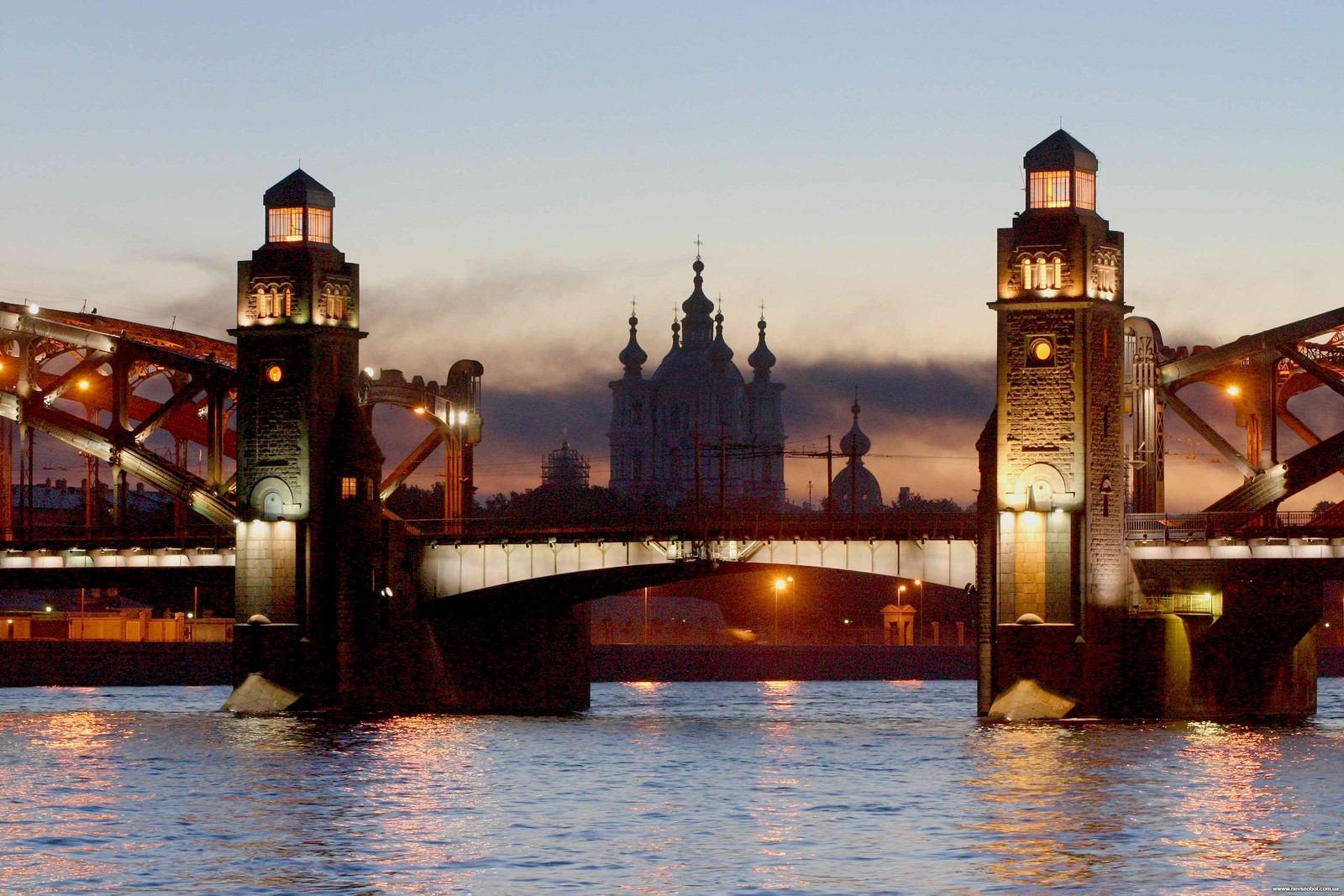 Uma ponte sobre um rio com uma torre do relógio ao fundo (marco, ponte, cidade, via navegável, anoitecer)