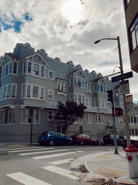 Charming Neighborhood Street View with Historic Building and Cloudy Sky