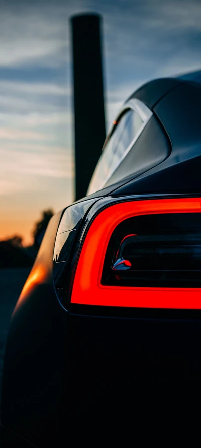 Elegant Sports Car Tail Light Against a Sunset Sky