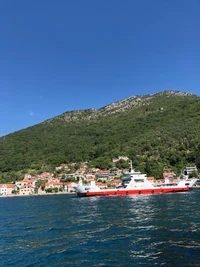 Boat Navigating Serene Waters Against a Mountainous Landscape