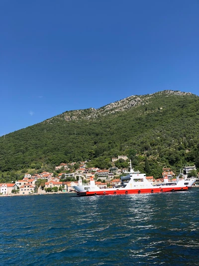 Barco navegando em águas serenas contra uma paisagem montanhosa