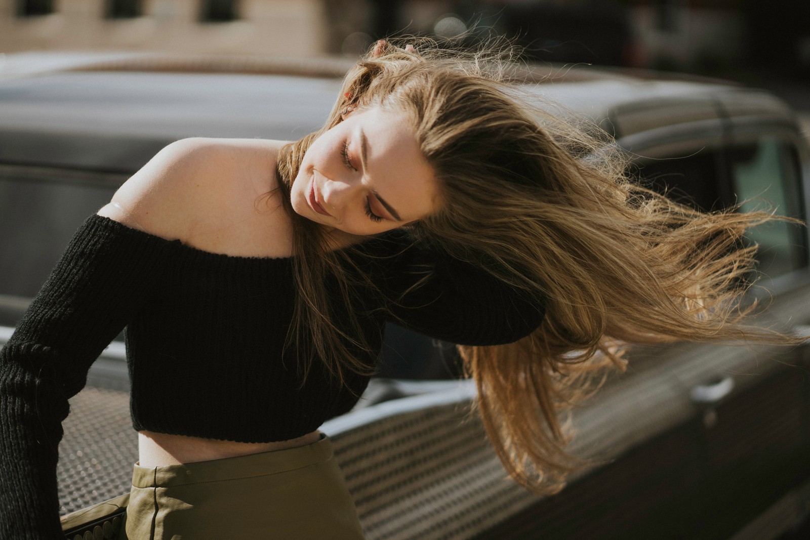 Una mujer árabe apoyada en un coche con la cabeza descansando en su brazo (cabello, rubio, belleza, hombro, pelo largo)