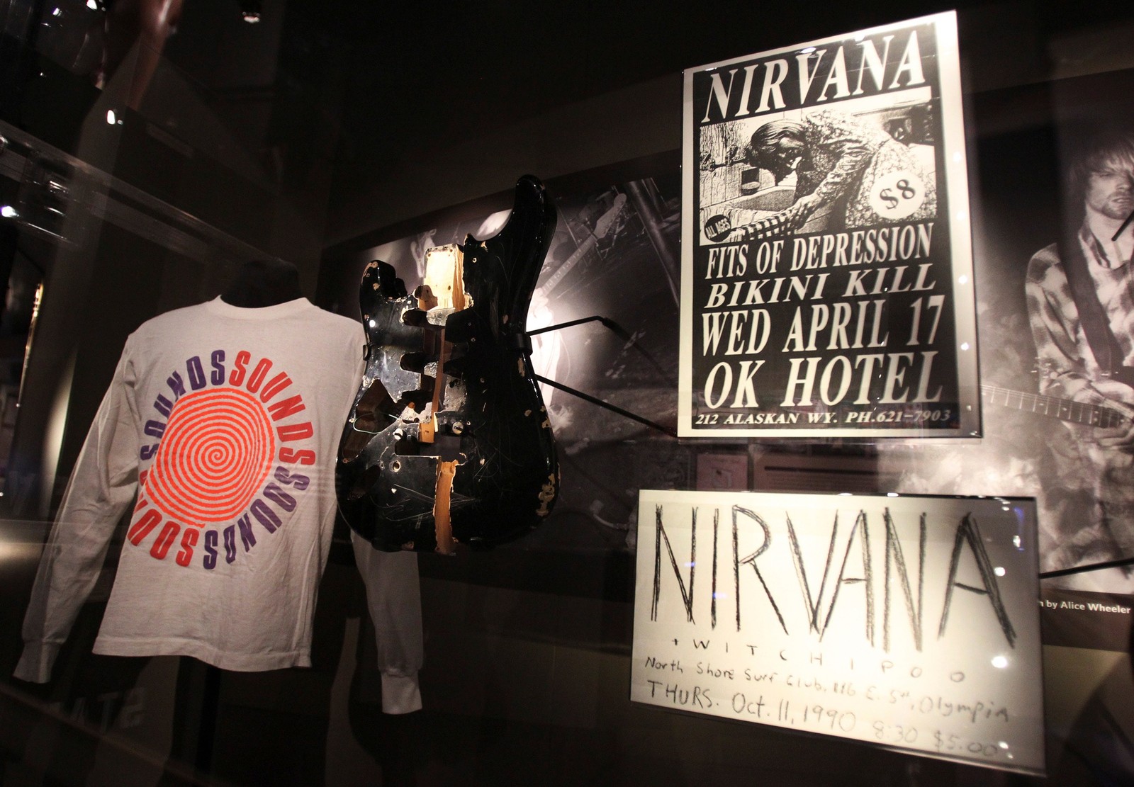 Exhibición de varios artículos, incluyendo una camiseta y una guitarra (nirvana, grunge, punk rock, museo, exposición de arte)