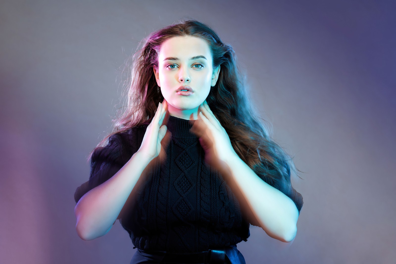 Femme arabe en robe noire posant avec les mains sur la poitrine (katherine langford, néon, actrice australienne, hannah baker, portrait)