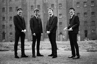 Die Beatles in Anzügen: Ein zeitloser Moment der Beatlemania in Schwarz und Weiß.