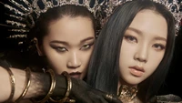 A cativante presença dual do Aespa, com Karina e Yoo Ji Min, adornadas com trajes impressionantes em preto e dourado com acessórios intrincados, incorpora a poderosa essência do K-pop.