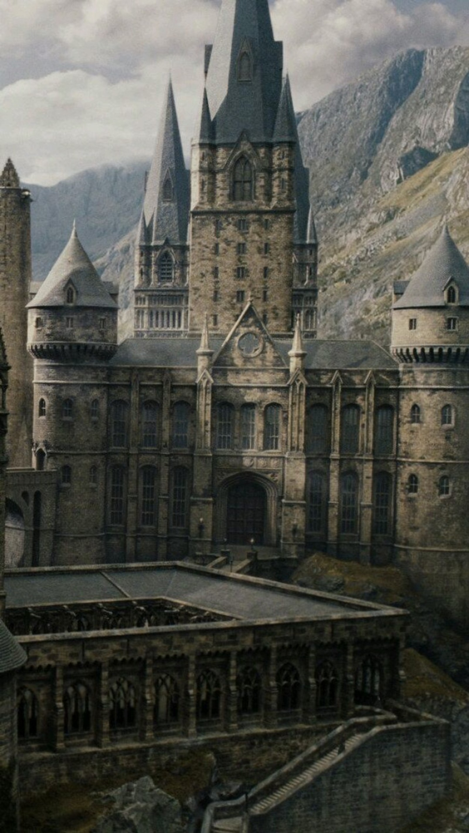 There is a castle with a clock tower in the middle of a mountain (castle, harry potter, hermione, ron, school)