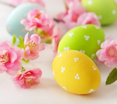 Oeufs de Pâques colorés entourés de fleurs roses