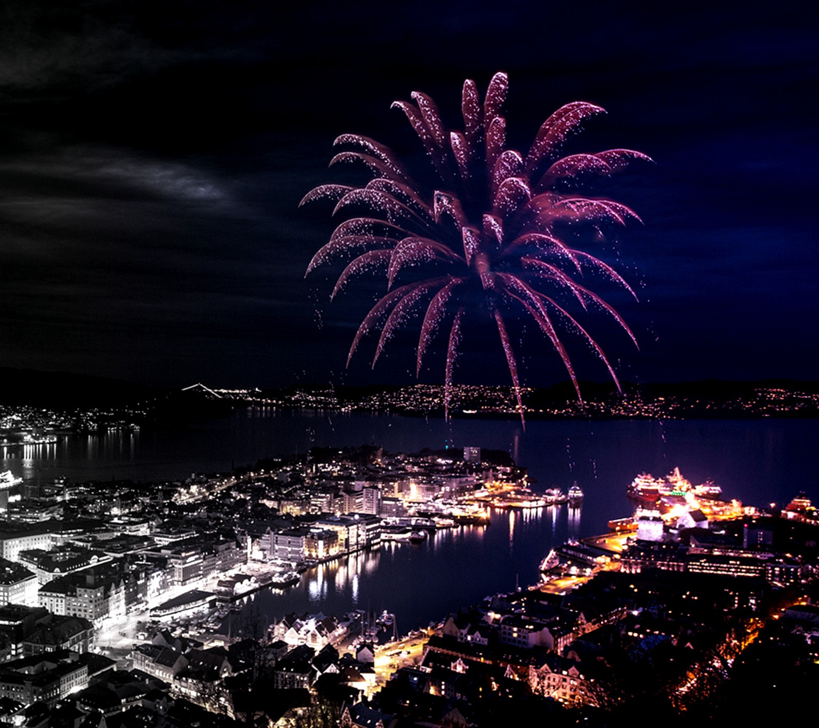 Feuerwerk am himmel über einer stadt mit einem hafen und einem großen gewässer (glücklich, neu, jahr)