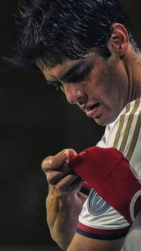 A focused athlete adjusting his red armband during a match, showcasing determination and commitment.