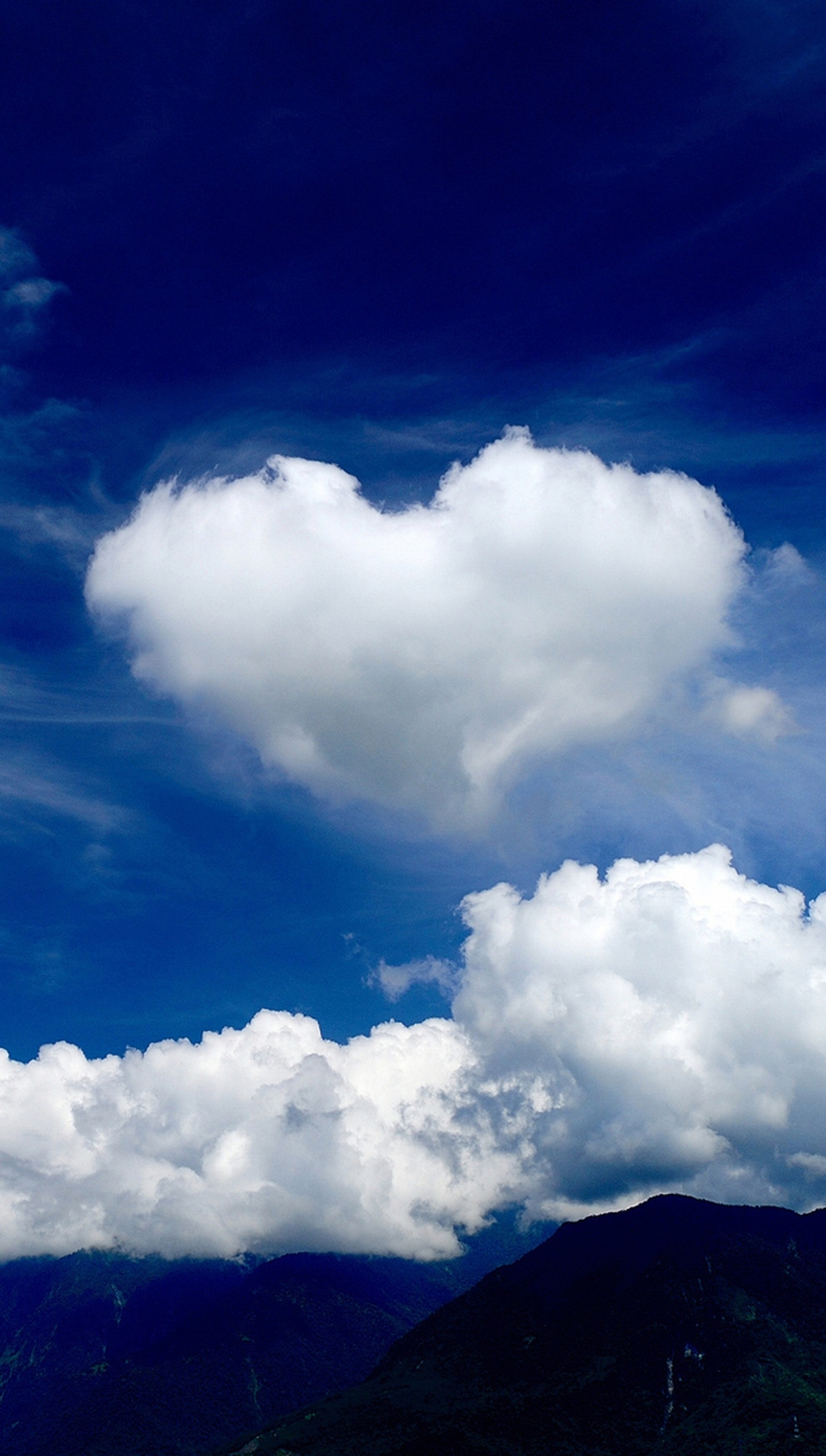 Un grand nuage dans le ciel au-dessus des montagnes (nuages, cœur, amour, nature, ciel)