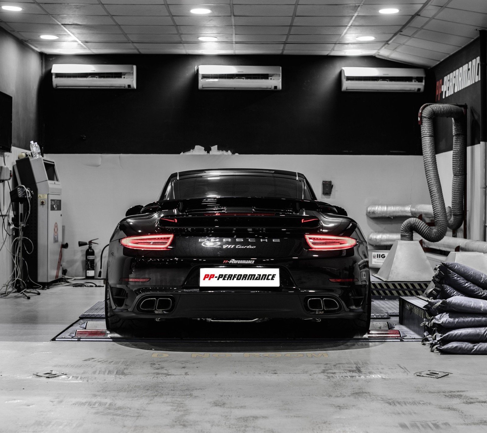 A close up of a car in a garage with a lot of equipment (auto, car, garage, porsche 911)