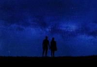 Couple en silhouette sous un ciel étoilé de minuit