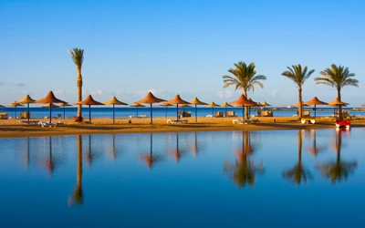 Serenes Küstenresort mit Palmen und ruhiger Reflexion bei Sonnenaufgang