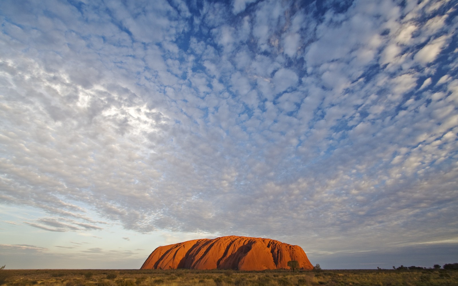 Vue aérienne d'un rocher au milieu d'un désert sous un ciel nuageux (uluru, nuage, horizon, petit déjeuner, calme)