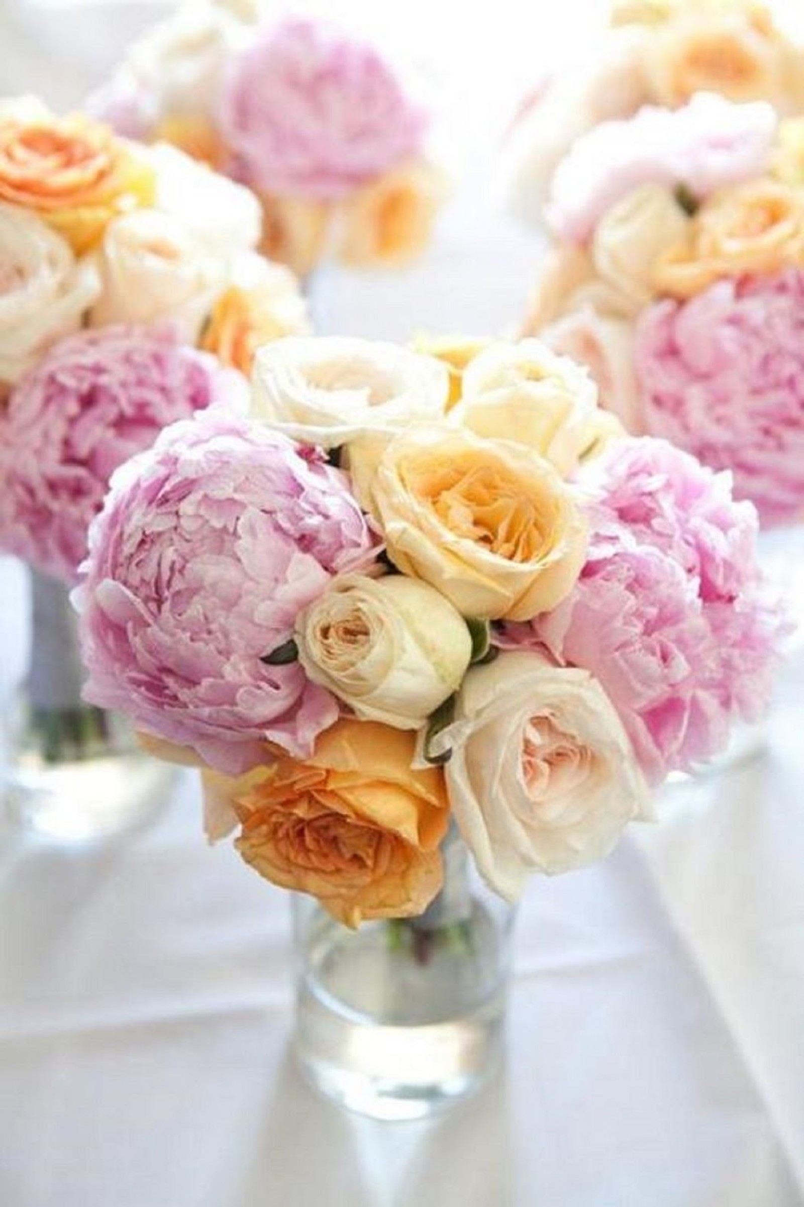 Il y a beaucoup de fleurs de différentes couleurs dans un vase sur une table (dessin floral, mariage, fleur, bouquet, roses de jardin)