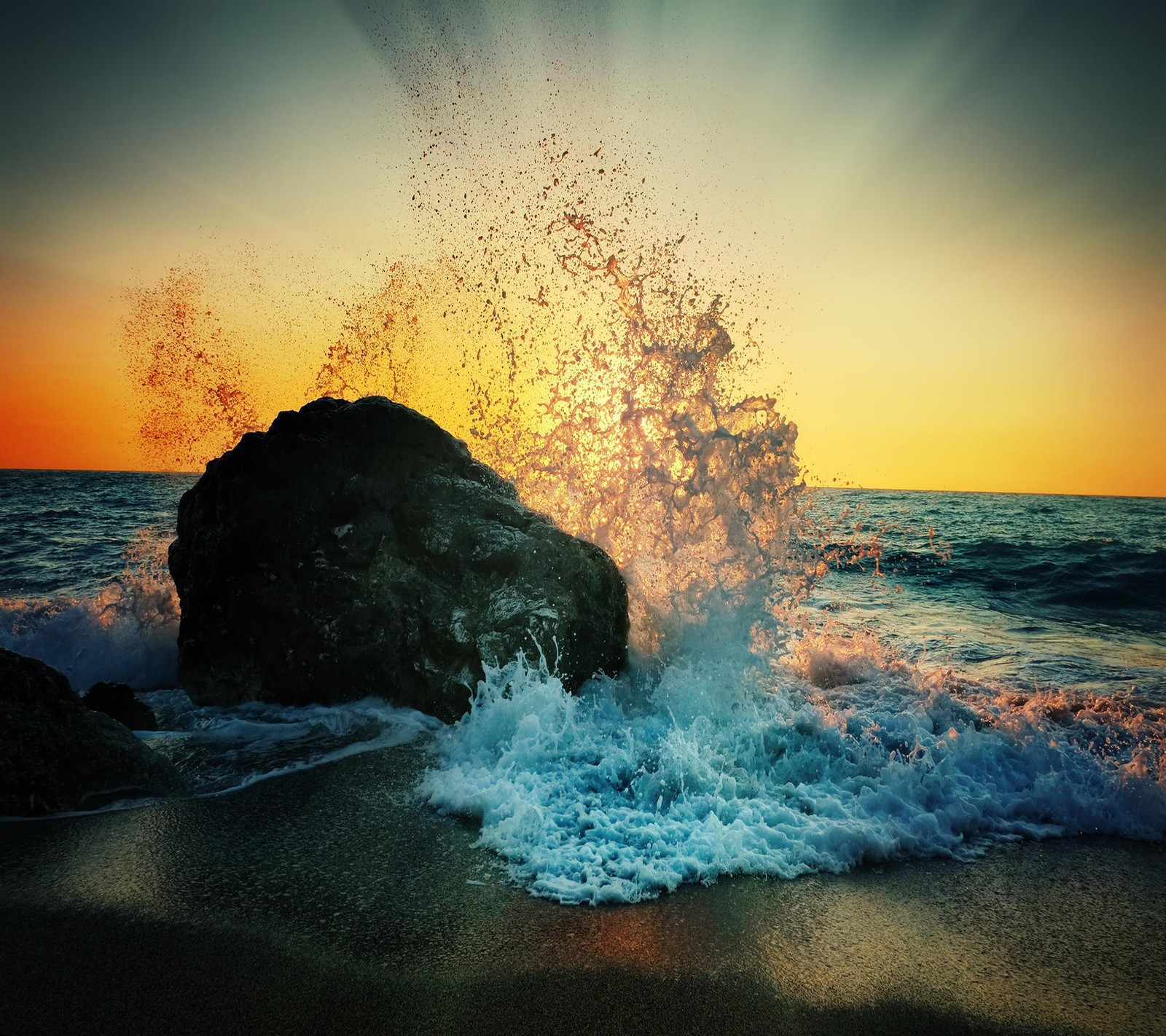 Eine welle, die bei sonnenuntergang gegen einen felsen am strand schlägt (schön, ozean)