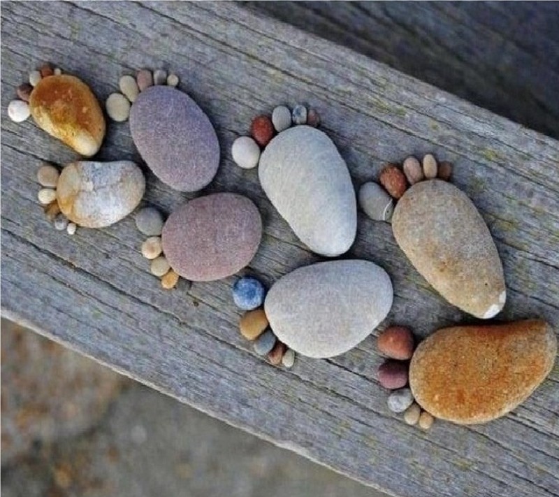 A close up of a wooden bench with rocks and stones on it (creative, nature, walls)