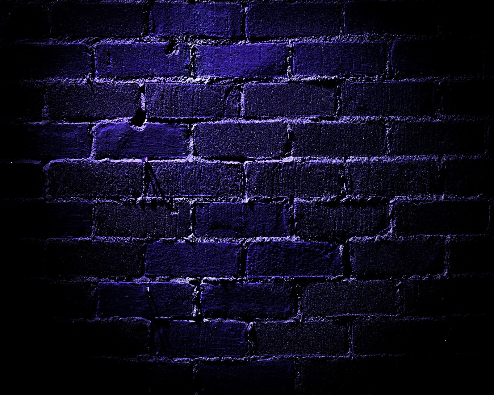 Gros plan d'un mur en brique avec une lumière violette (bleu, mur en briques)