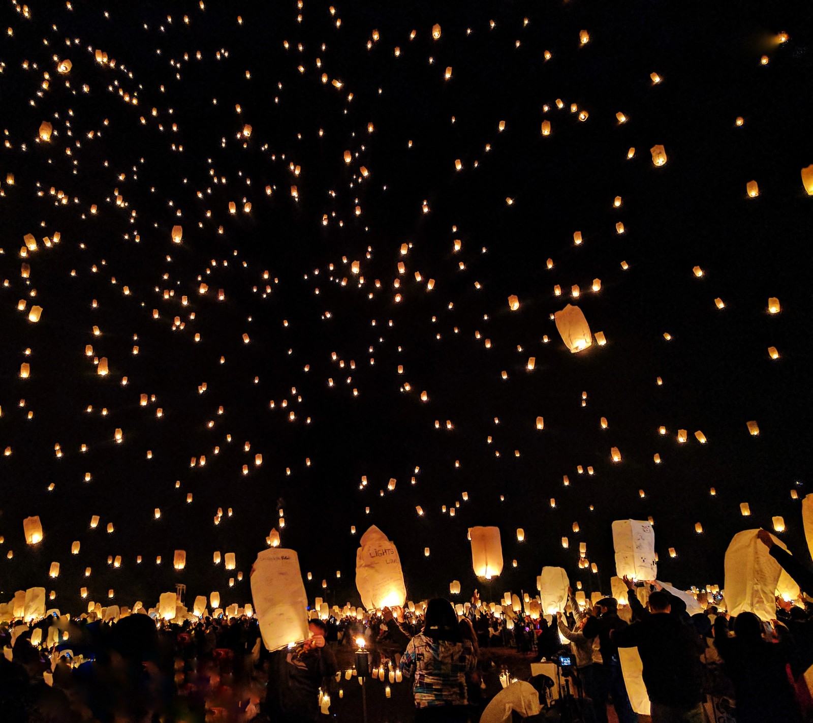 Mucha gente está volando linternas en el cielo por la noche (arizona, este, littlefield, estados unidos)