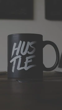 Caneca de café preta com a inscrição 'HUSTLE