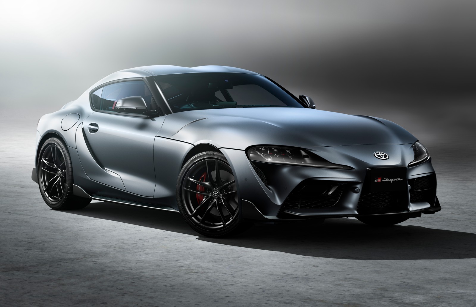 A silver sports car is shown in a studio setting (toyota gr supra rz, anniversary edition, 2021, cars, 4k wallpaper)