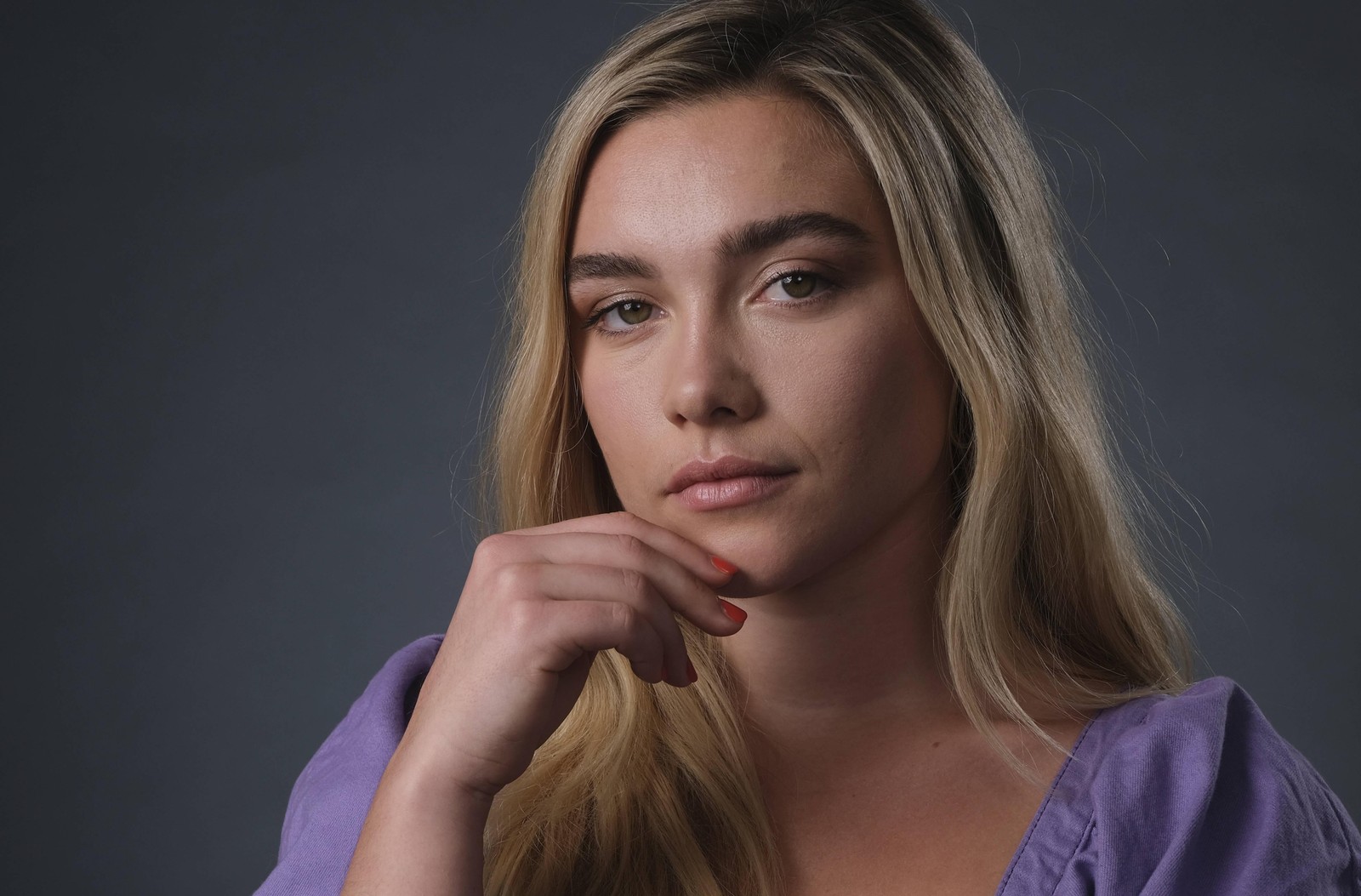 Femme blonde avec la main sur le menton regardant la caméra avec un air sérieux. (florence pugh, portrait, actrice anglaise, gens, fond décran 4k)