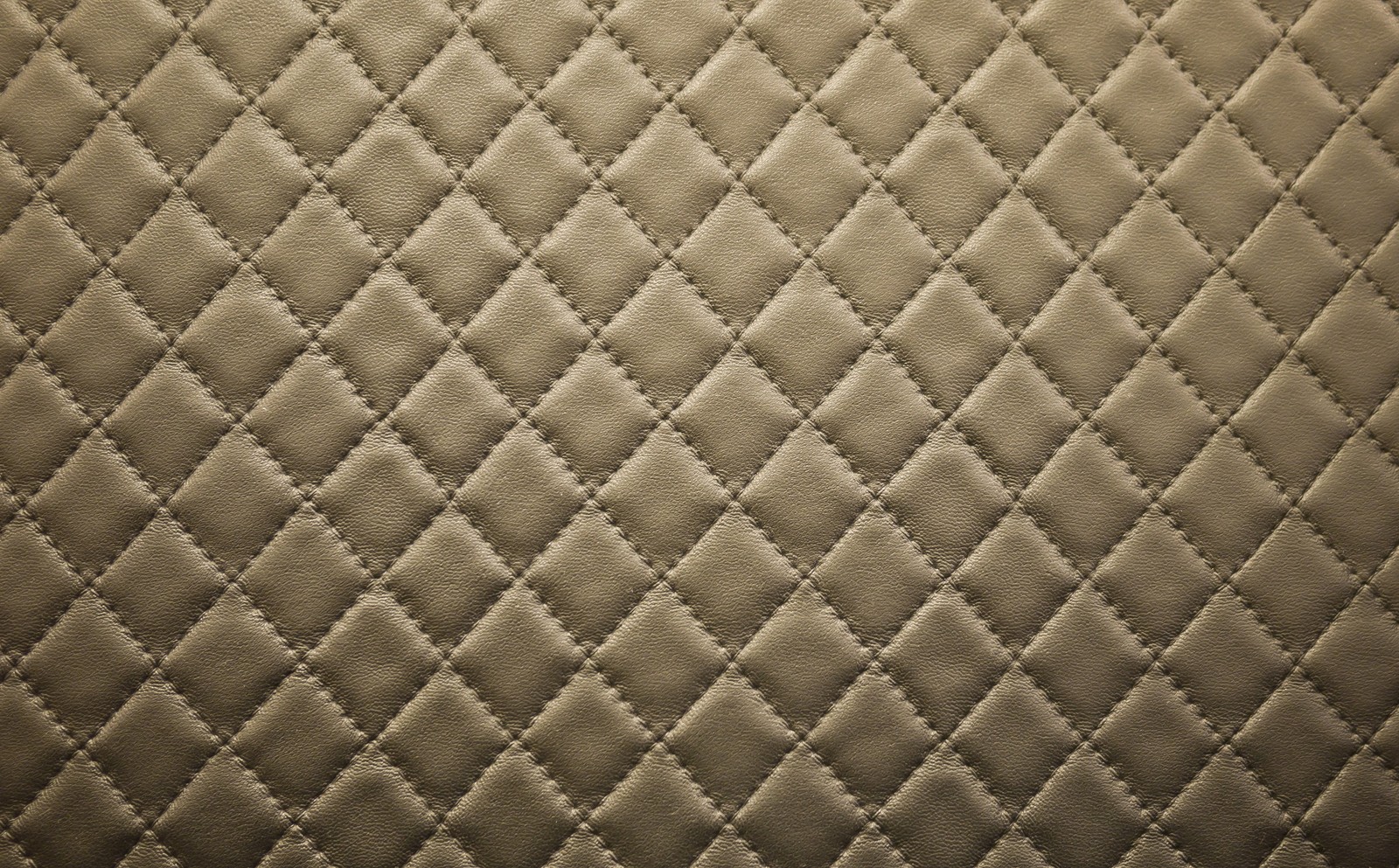 A close up of a quilted surface with a diamond pattern (handbag, leather, brown, pattern, symmetry)