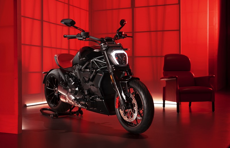 Близкий план мотоцикла, припаркованного в комнате с красными стенами (ducati xdiavel nera, 8k, ограниченное издание, спортивный круизер, красный фон)