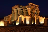 Ruines illuminées d'un ancien temple égyptien la nuit, mettant en valeur l'architecture monumentale et l'importance historique le long du Nil.