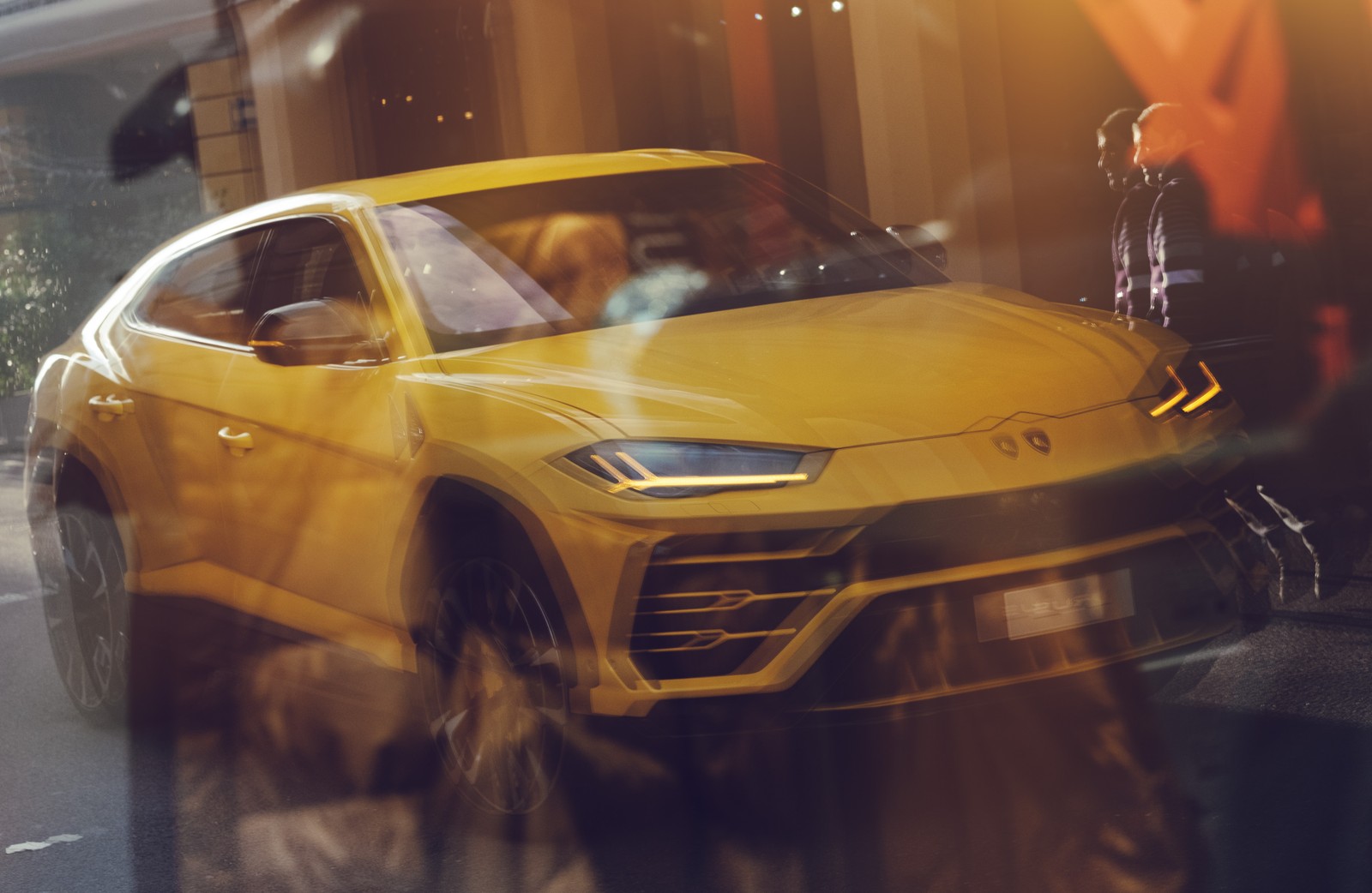 A close up of a yellow lamb suv driving down a street (auto show, car, lamborghini, yellow, supercar)