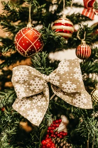 Árbol de Navidad festivo adornado con vibrantes adornos y un lazo con patrón de copos de nieve.