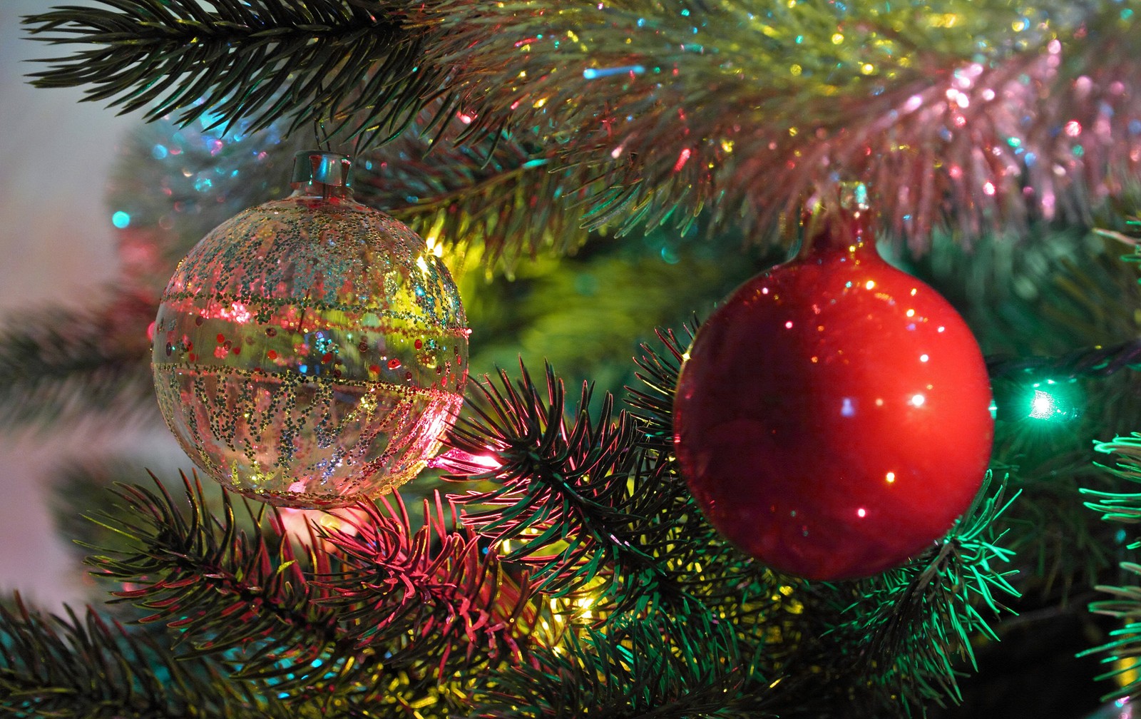 Hay dos adornos en un árbol de navidad con una bola roja (adorno de navidad, árbol de navidad, luces navideñas, día de navidad, navidad)