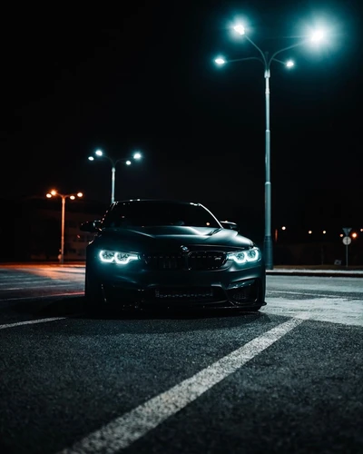 BMW M4 Coupé noir sous les lumières de la nuit