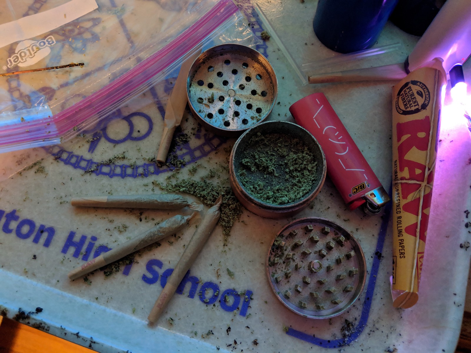 A close up of a table with a lot of marijuana and other items (lil tom)