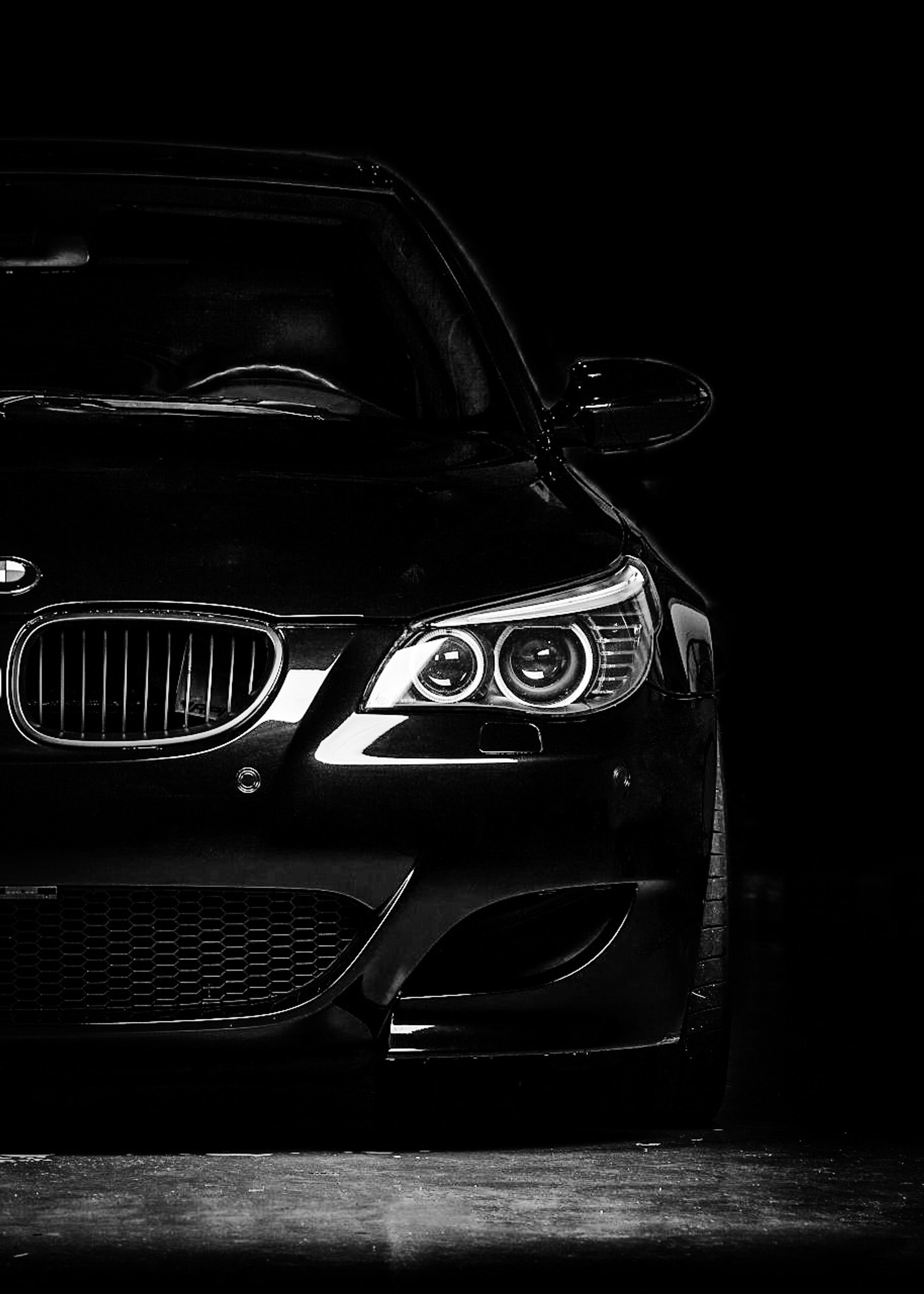 Una foto en blanco y negro de un coche en una habitación oscura. (negro, blanco y negro, bmw, bmw e60, bmw m5)