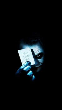 Joker Sosteniendo Carta 'Alea Jacta Est' en las Sombras