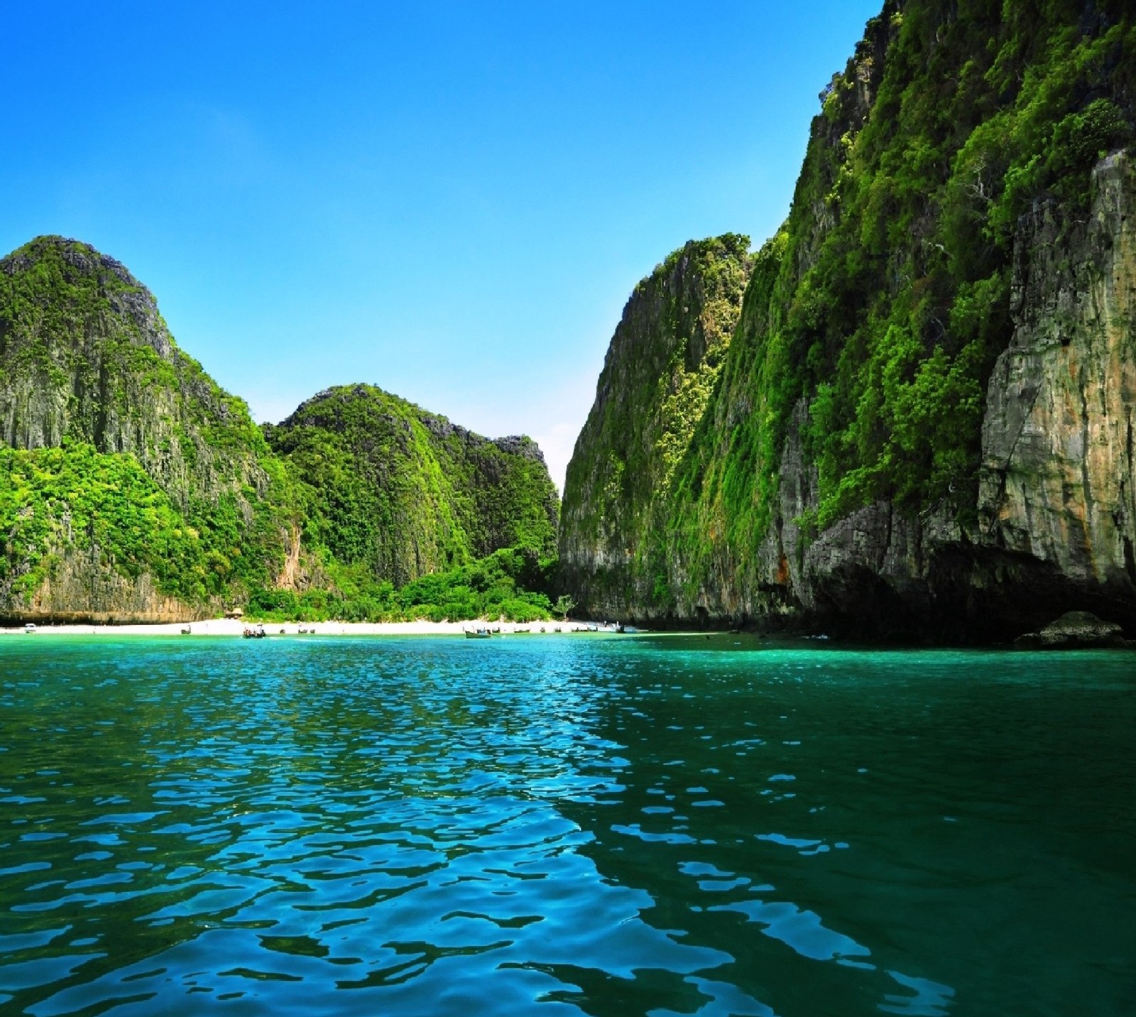 A view of a beach with a body of water and a mountain (nature)