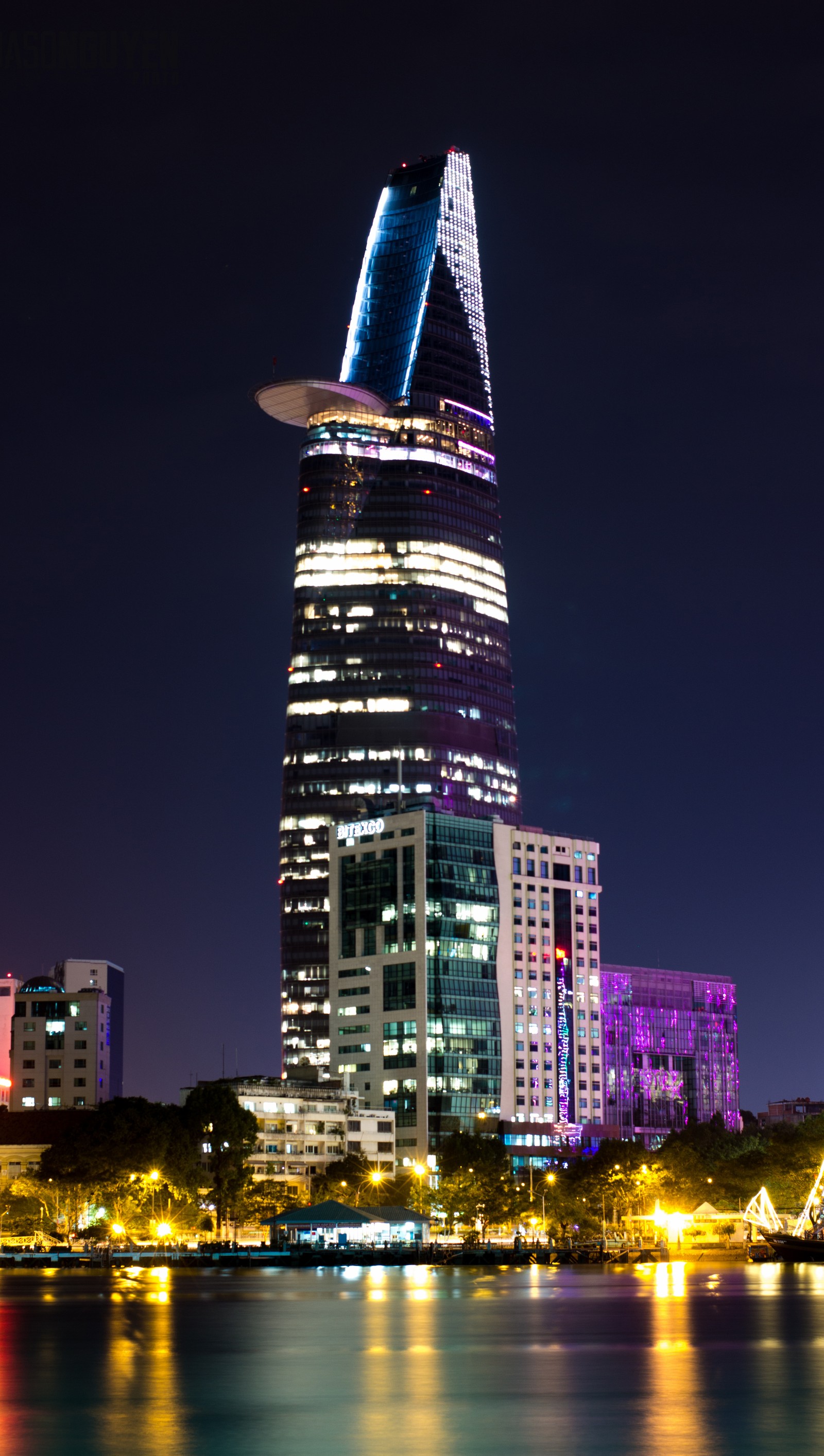 Vista araphed de una ciudad de noche con un barco en el agua (bitexco, hcmc, jason nguyen)