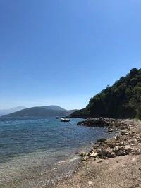 Línea de costa aislada con promontorio rocoso y aguas tranquilas