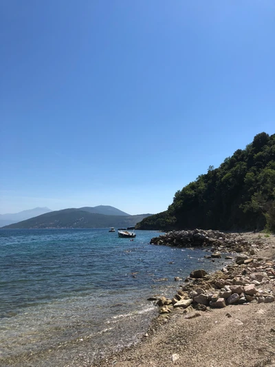 Secluded Shoreline with Rocky Promontory and Calm Waters