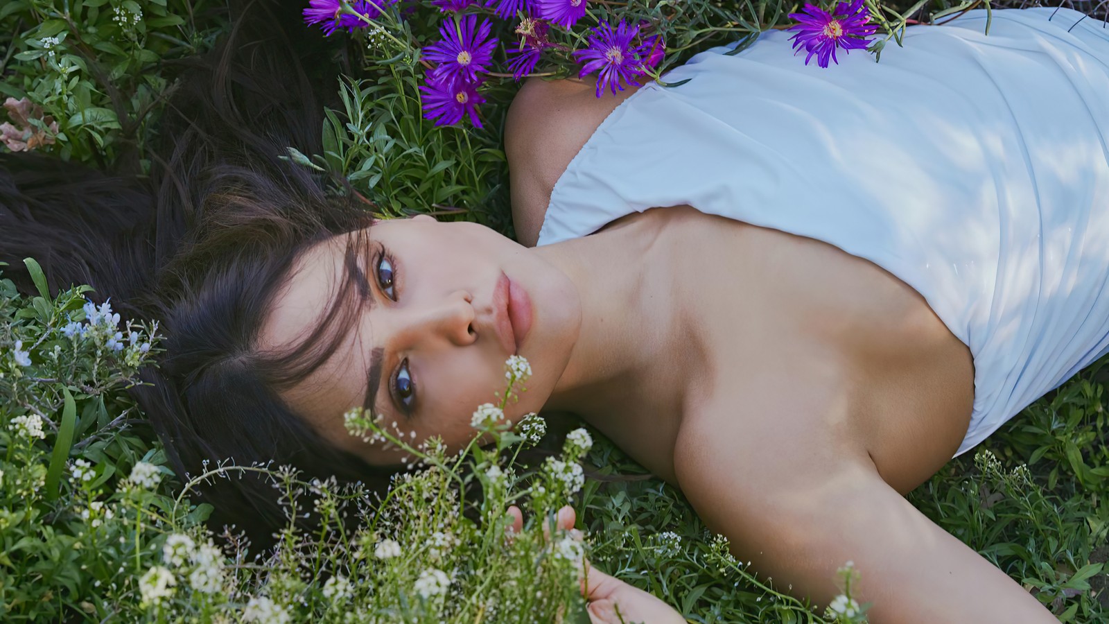 Femme arabe allongée dans l'herbe avec des fleurs dans les cheveux (eiza gonzález, eiza gonzalez, mexicain, actrice, célébrité)