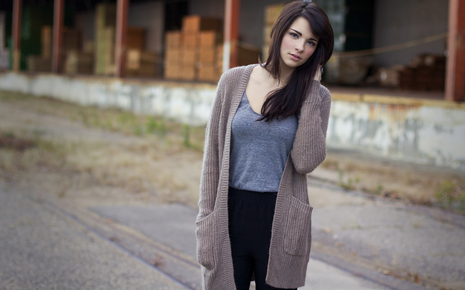 Arabische frau in grauem shirt und schwarzen hosen, die auf der straße steht (kleidung, oberbekleidung, schönheit, pullover, emily rudd)