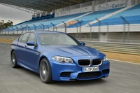 BMW M5 em movimento dinâmico em uma pista de corrida, mostrando seu design elegante e capacidades de desempenho.