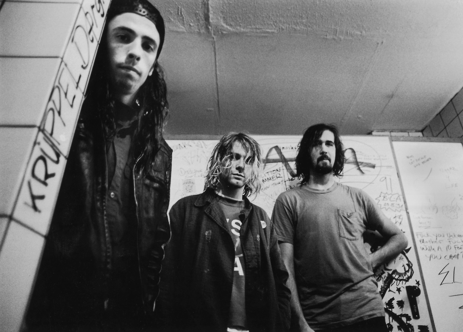 Una foto en blanco y negro de tres hombres en un baño (dave grohl, nirvana, negro, monocromo, foto instantánea)