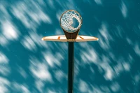 Basketball Hoop Under Turquoise Sky with Reflections