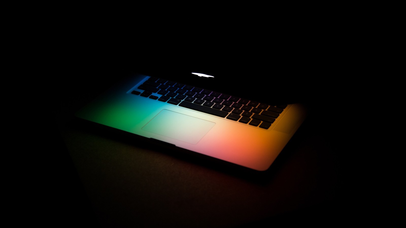 A close up of a laptop computer with a rainbow light on the keyboard (light, technology, space bar, lighting, tech)