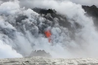 Flujo de lava erupcionando entre nubes volcánicas