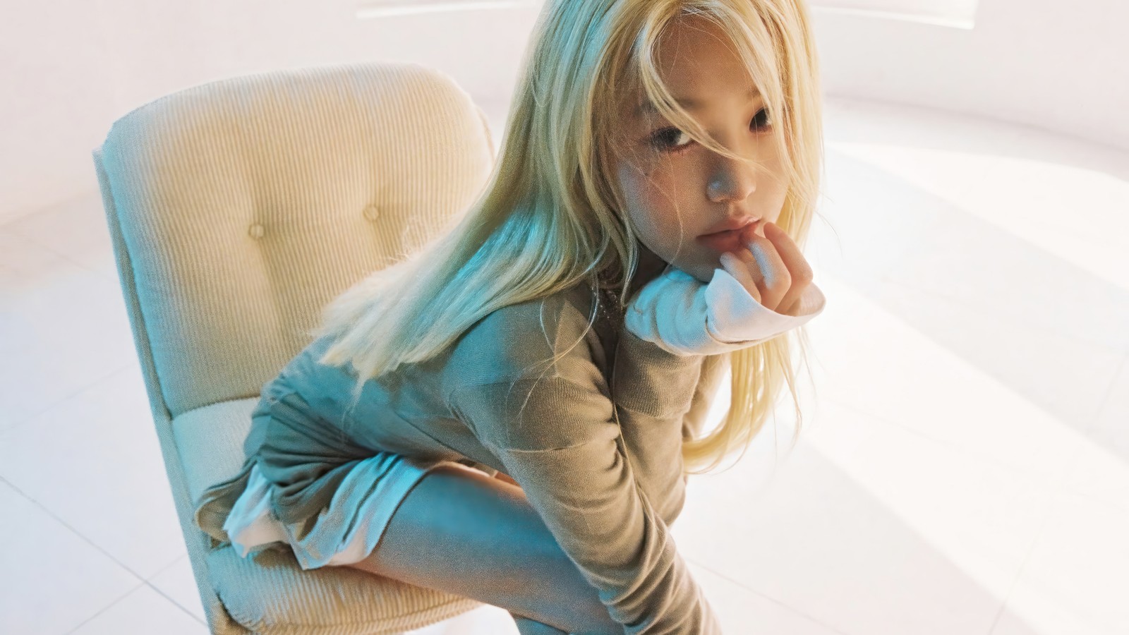 Una chica rubia sentada en una silla con la mano en la barbilla (wonyoung, won young, 원영, jang won young, jang wonyoung)