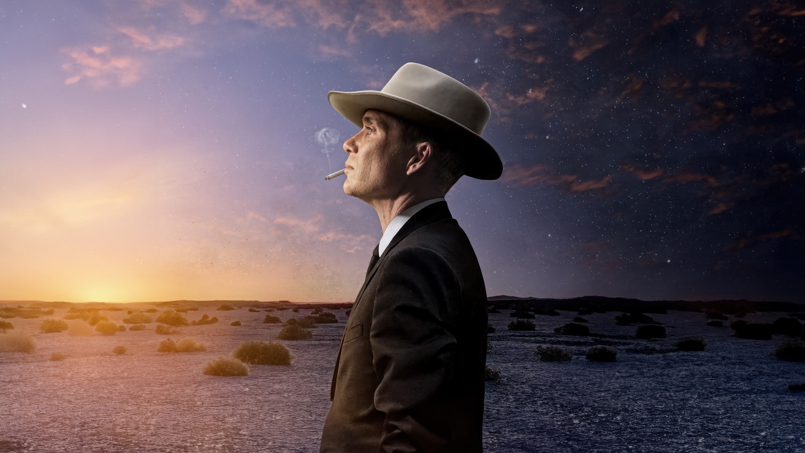 Un hombre árabe en traje y sombrero fuma un cigarrillo en el desierto. (oppenheimer, película, cillian murphy)